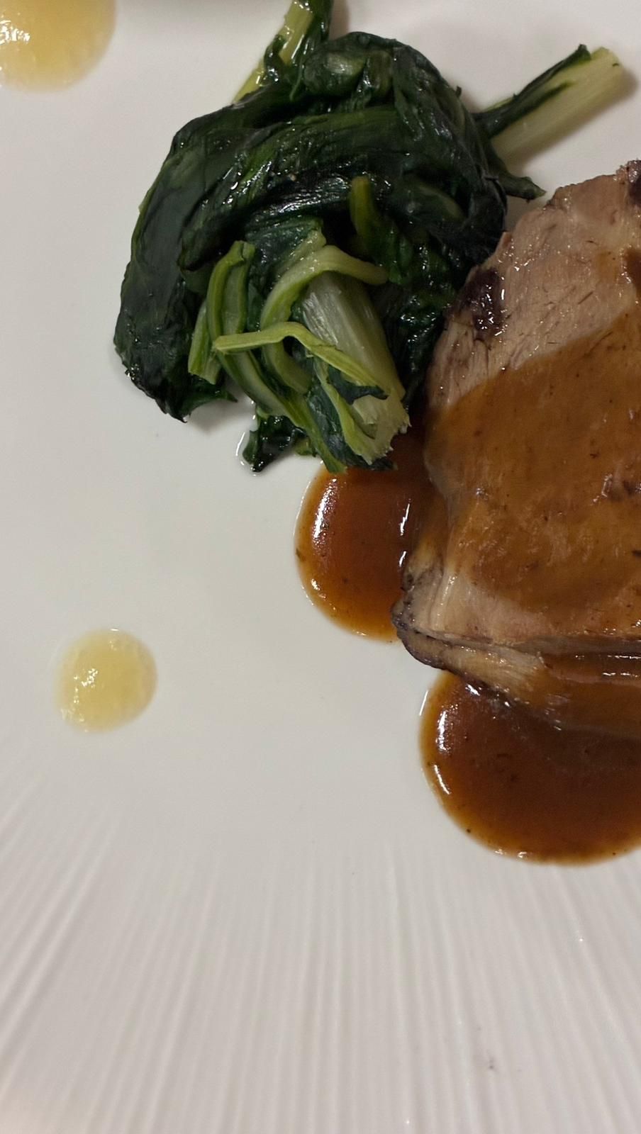 Polpo grigliato servito su tortino di patate, con purea di avocado, cipolle rosse sottaceto e olive.