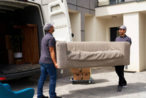 Two men transporting a couch in front of a moving van, demonstrating local moving service.