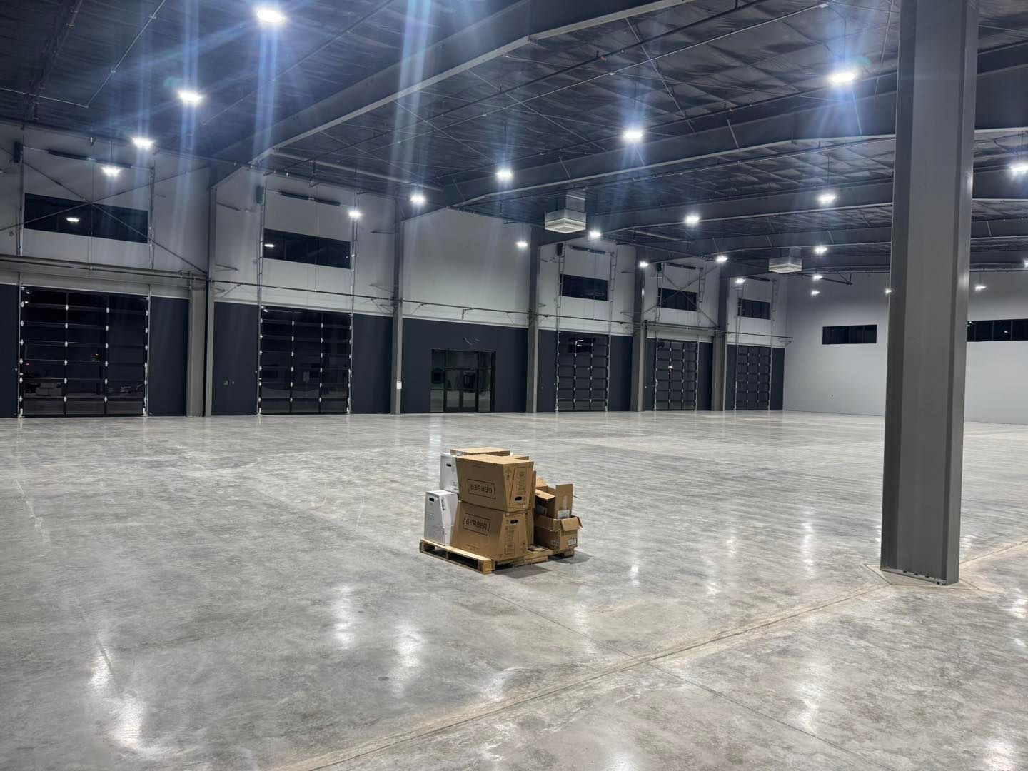 Empty warehouse interior with polished concrete floor and stacked boxes on a pallet