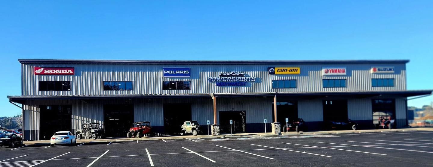Blue retail strip mall with multiple storefronts and parking lot in front