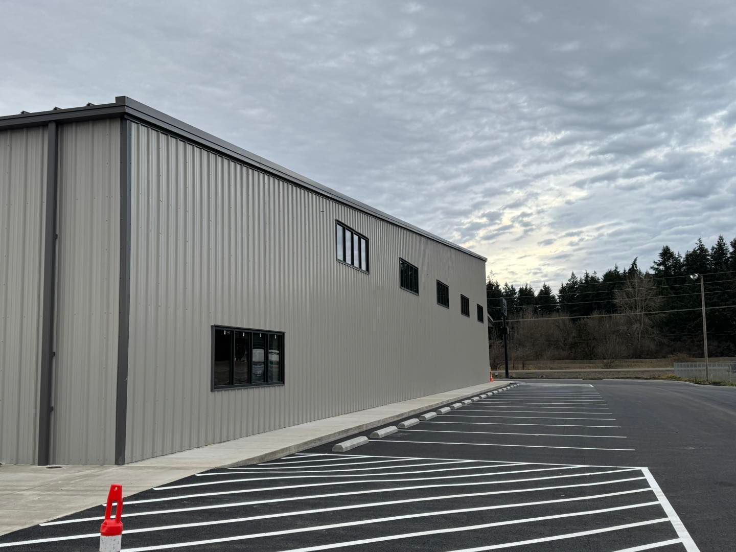 Industrial building exterior with striped parking lot and overcast sky
