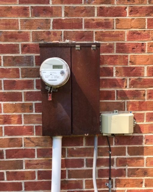 A brick wall with a meter on it