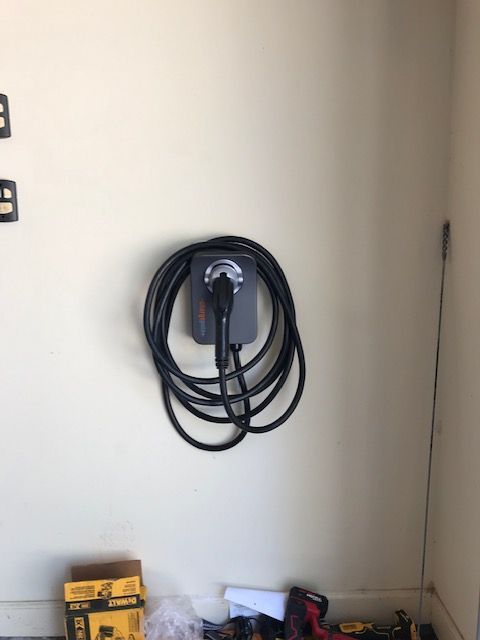 A hose is hanging on a wall next to a box of dewalt tools