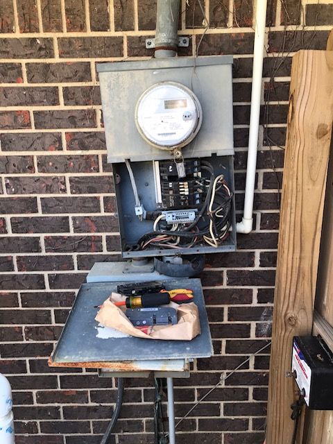 A brick wall with a meter and tools on a table