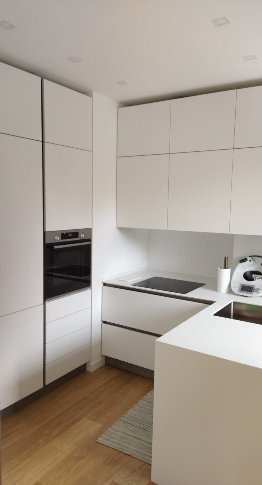 Spezzone cucina Dibiesse modello Area 22 in laccato opaco bianco. pensili doppia altezza fino a soffitto. apertura gola curva. top in solid top hpl gesso. penisola centrale con zona lavello. realizzata per un nostro cliente