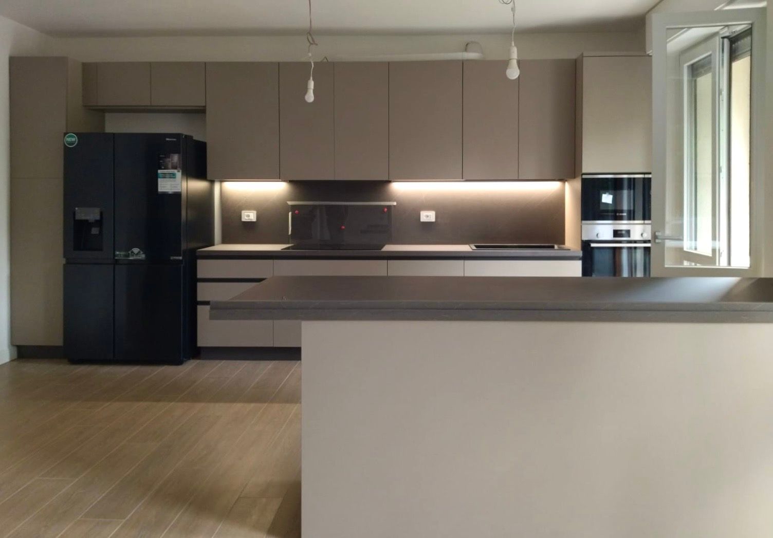 Cucina lineare con isola, del Brand Ar-due, modello Easy in laminato opaco con profilo 575. piano e schienale in HPL. illuminazione led sotto pensile. elettrodomestici Bosch. realizzata per un nostro cliente