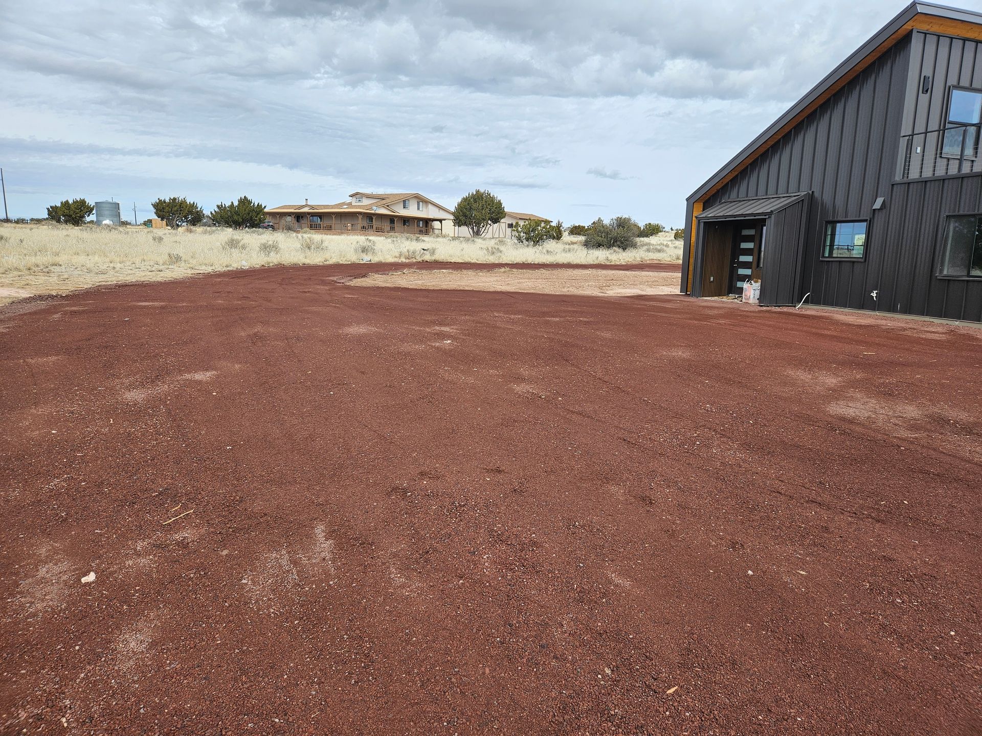 A white dump truck is parked in a dirt field