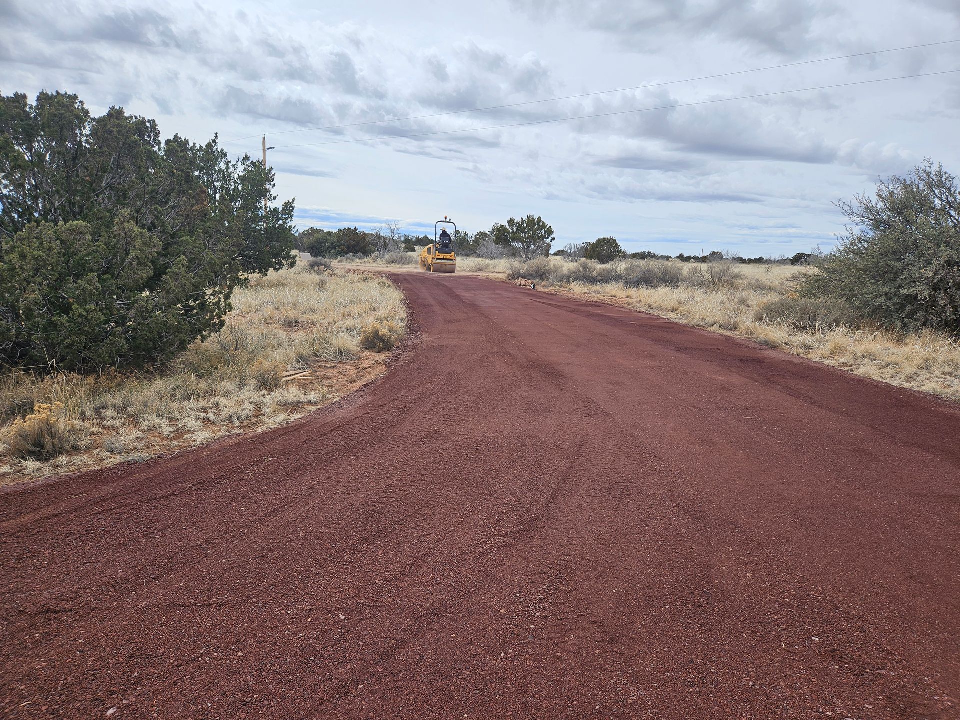 A white dump truck is parked in a dirt field