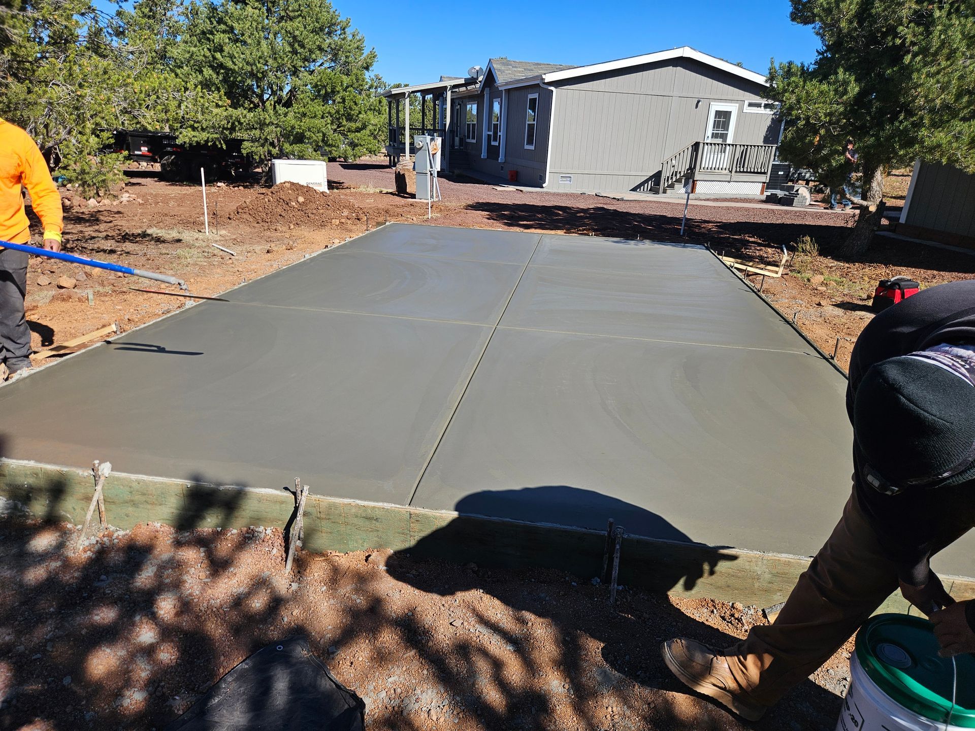 A white dump truck is parked in a dirt field