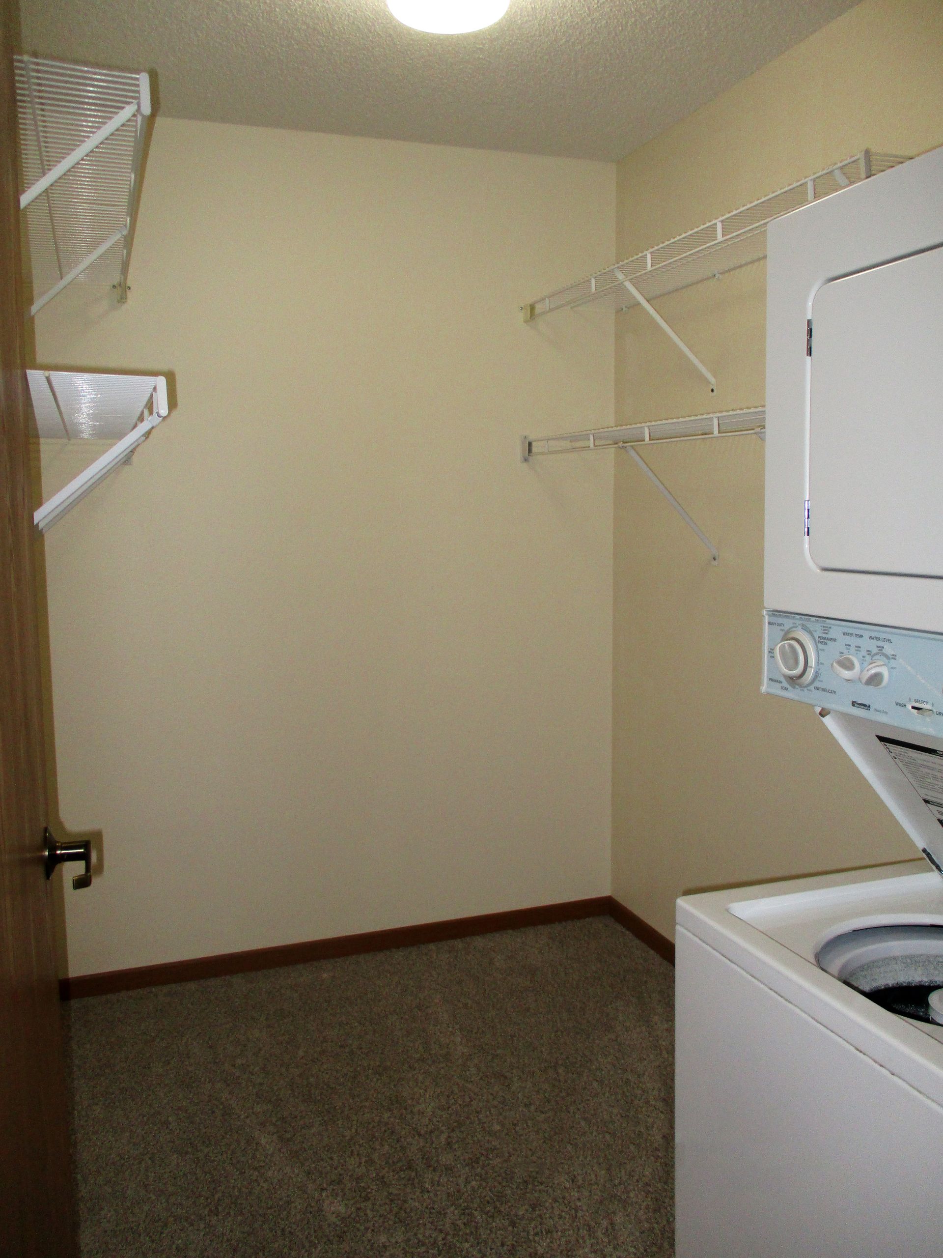 A laundry room with a washer and dryer stacked on top of each other.