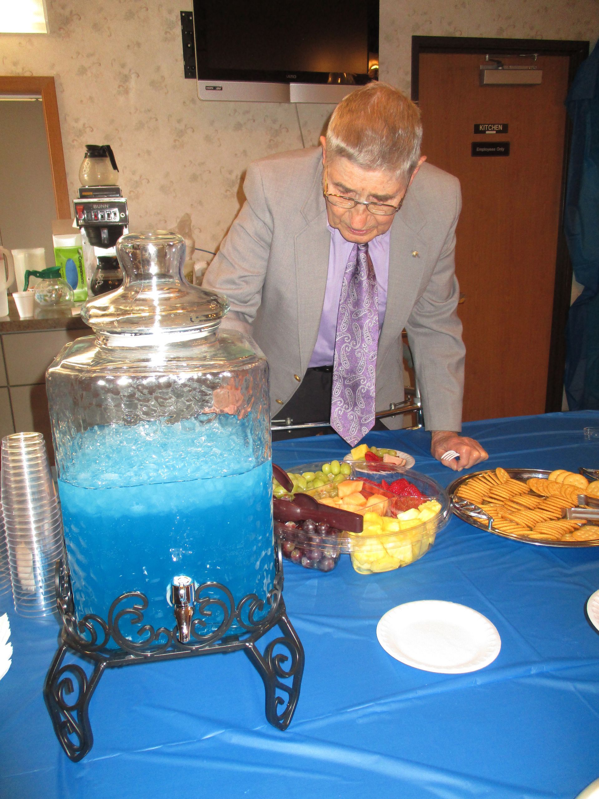 A man in a suit and tie is standing at a table with food