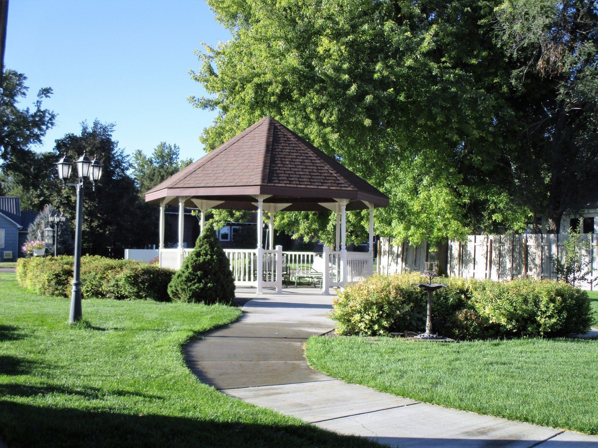 A gazebo in a park with a walkway leading to it