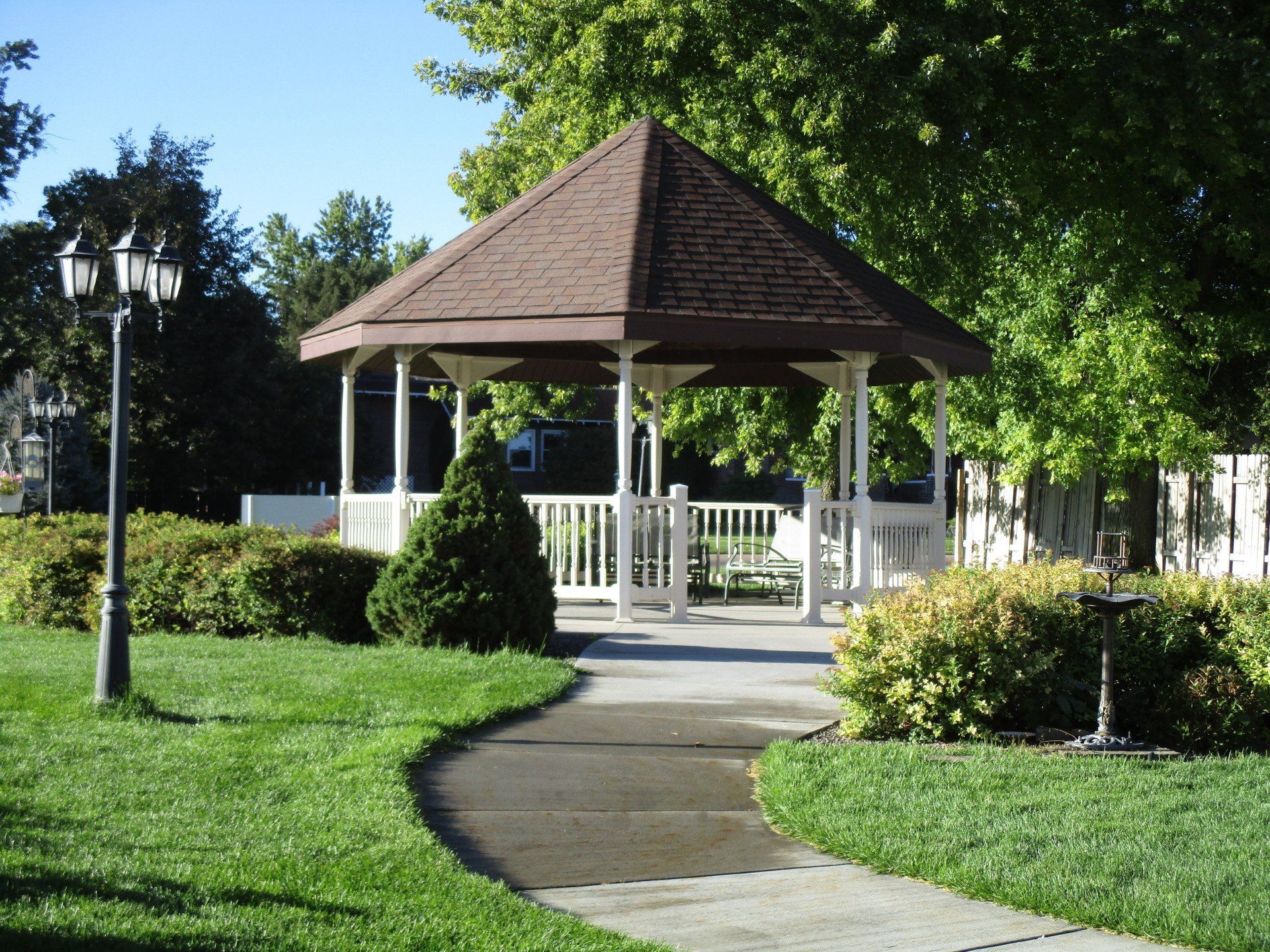 A gazebo in a park with a walkway leading to it