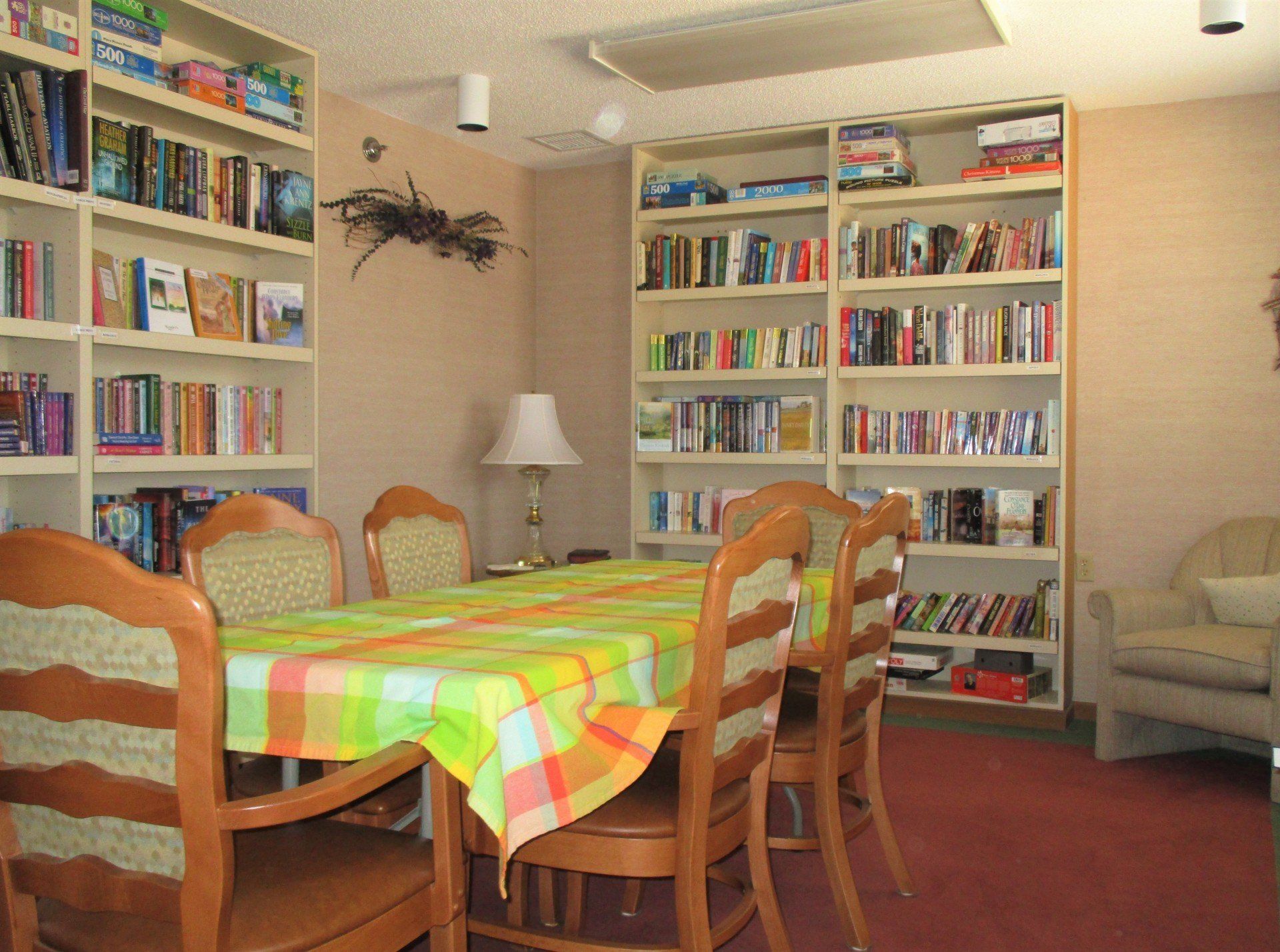 A dining room with a table and chairs in front of bookshelves