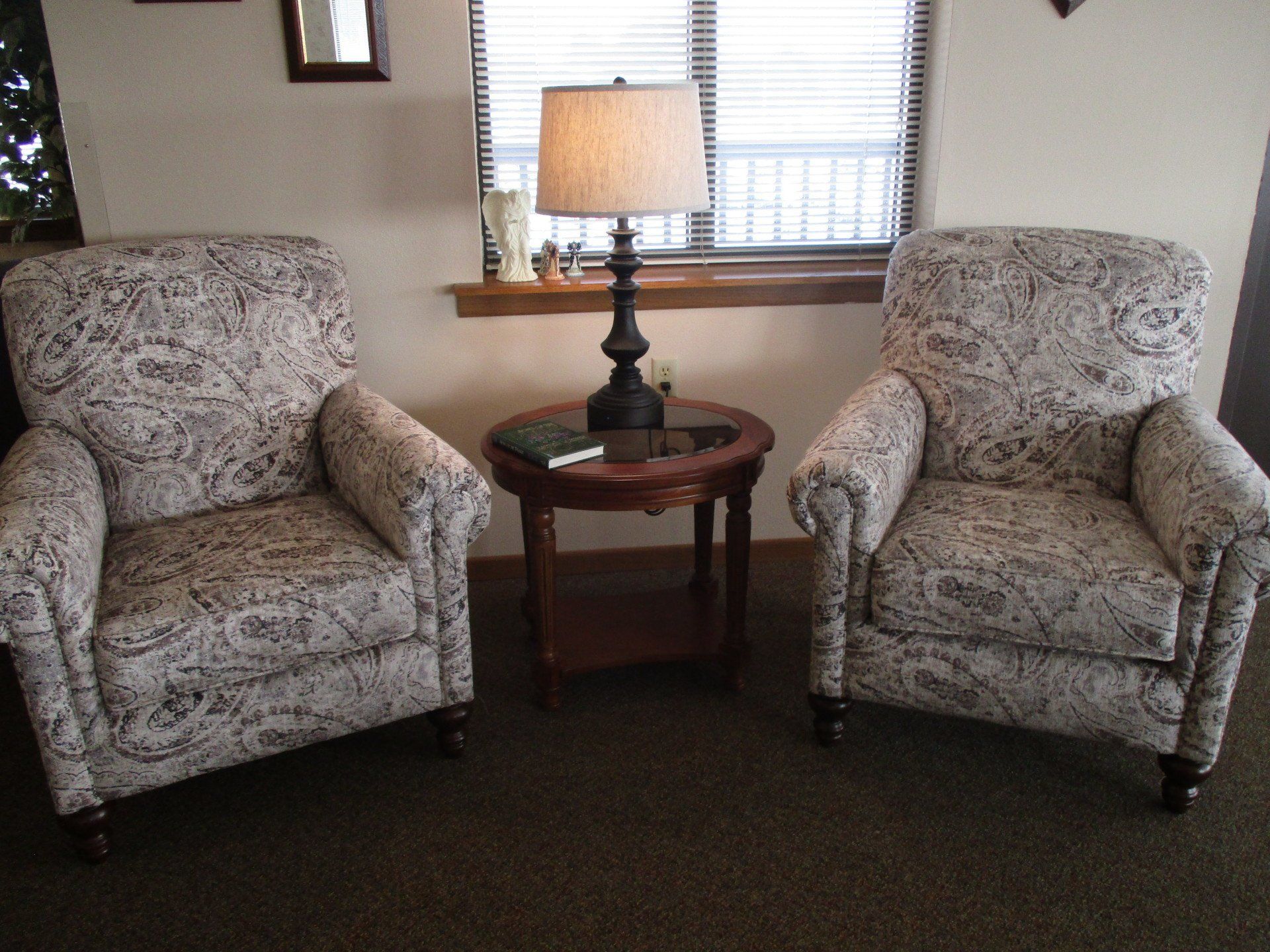 A living room with two chairs and a lamp