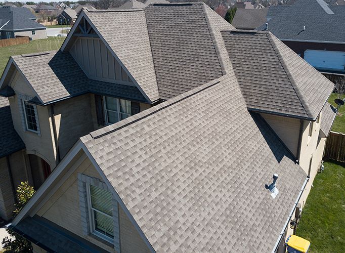An aerial view of a house with a gray roof
