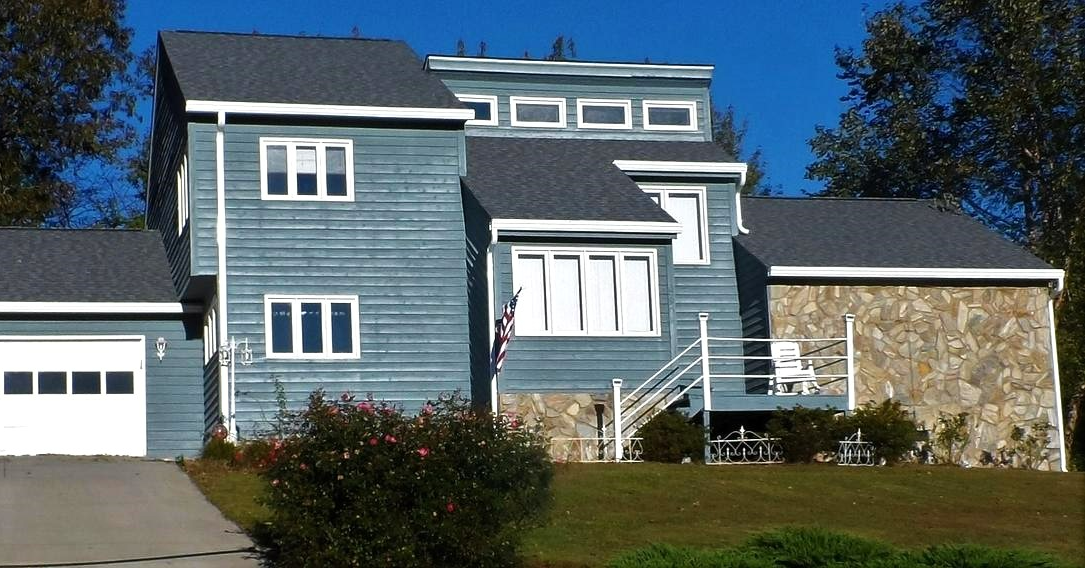 A large blue house with a white garage door