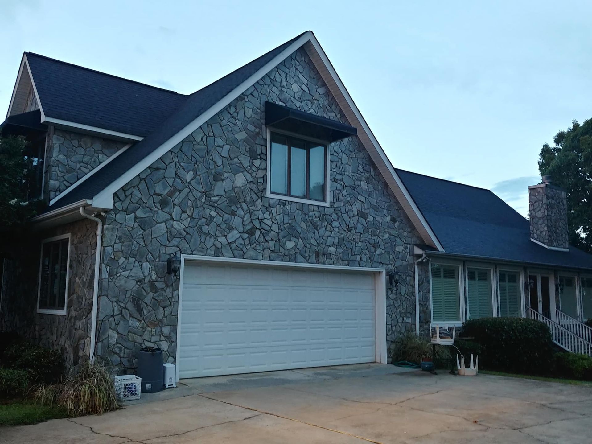 A large stone house with a white garage door