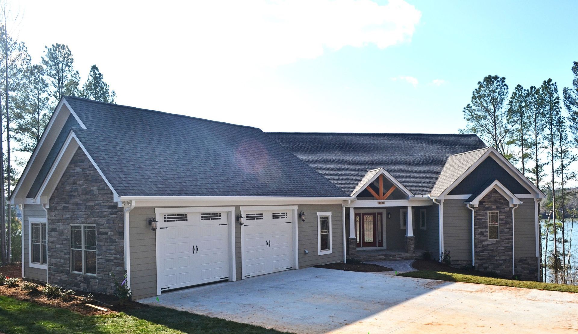 A large house with three garage doors and a driveway