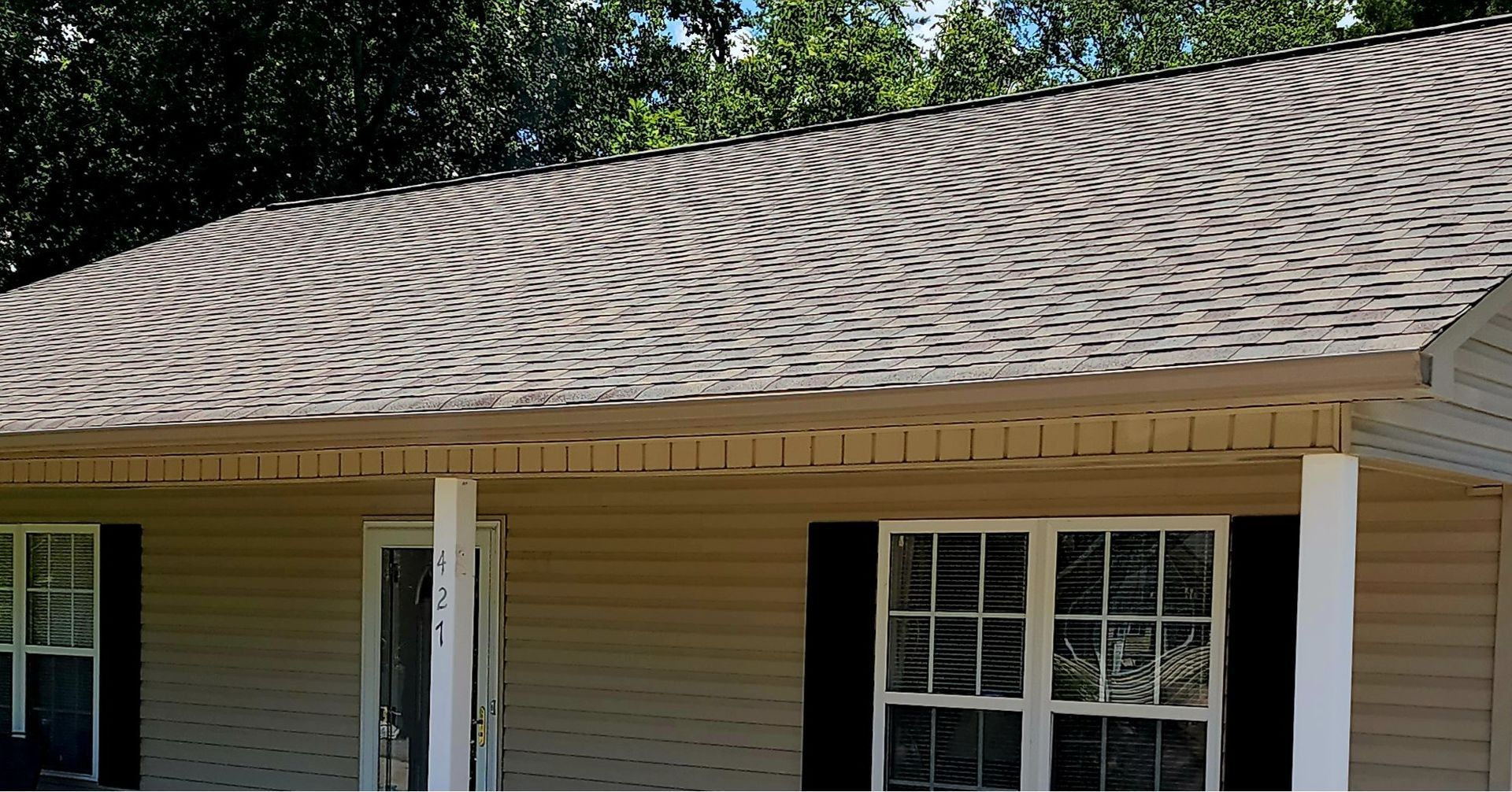 A house with a large roof and a porch.