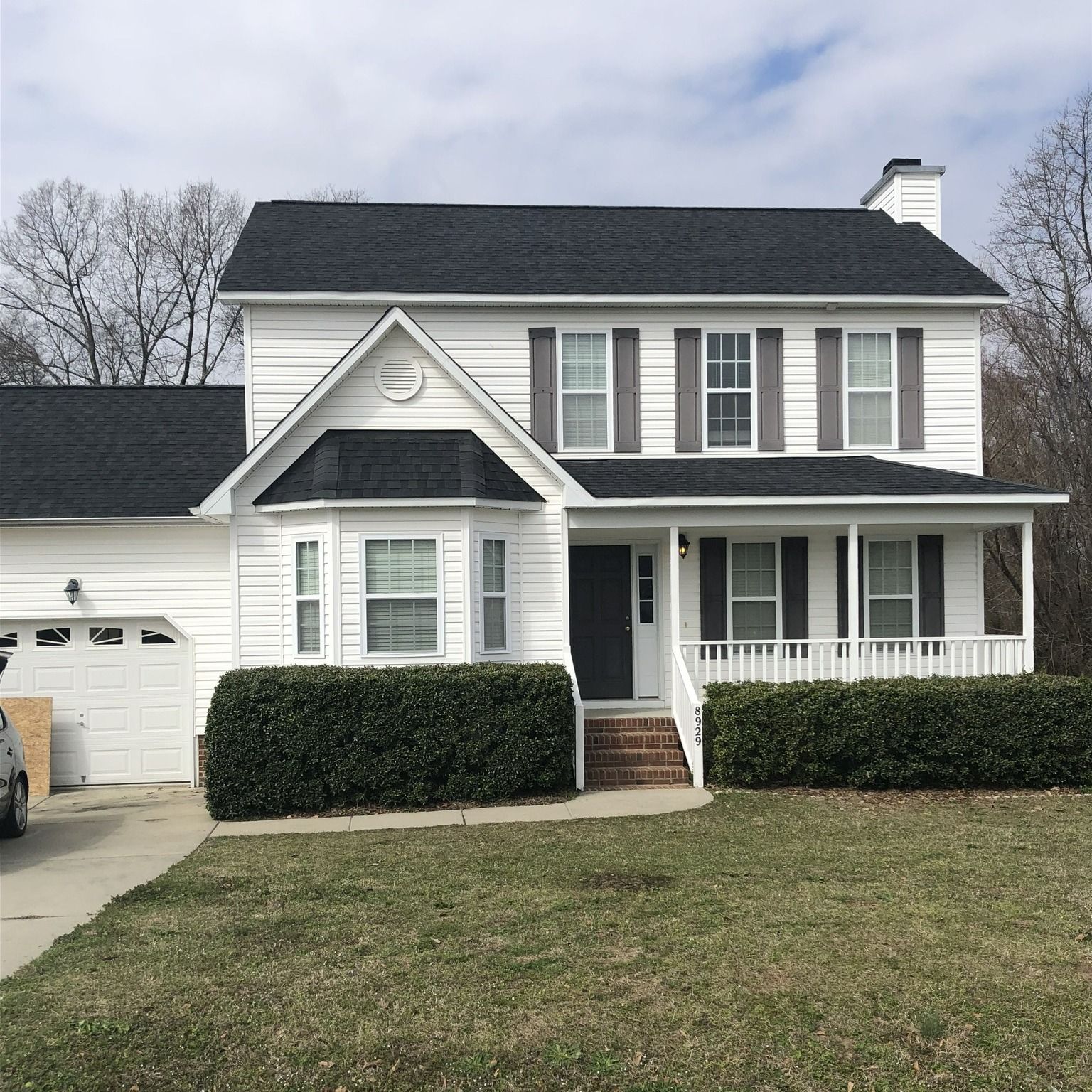 A white house with a black roof and black shutters