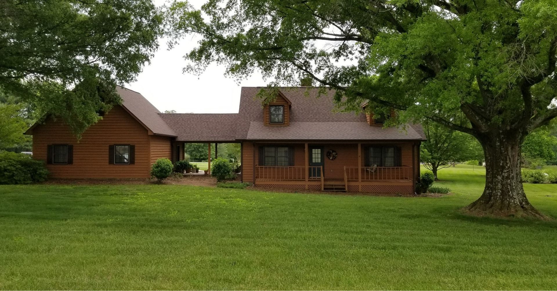 A log cabin is sitting in the middle of a lush green field.