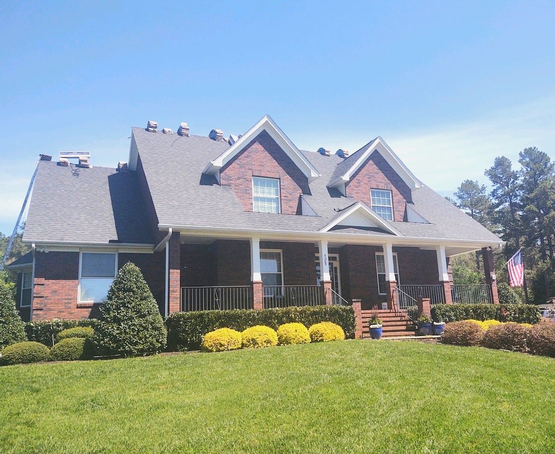 A large brick house with a roof that is being installed