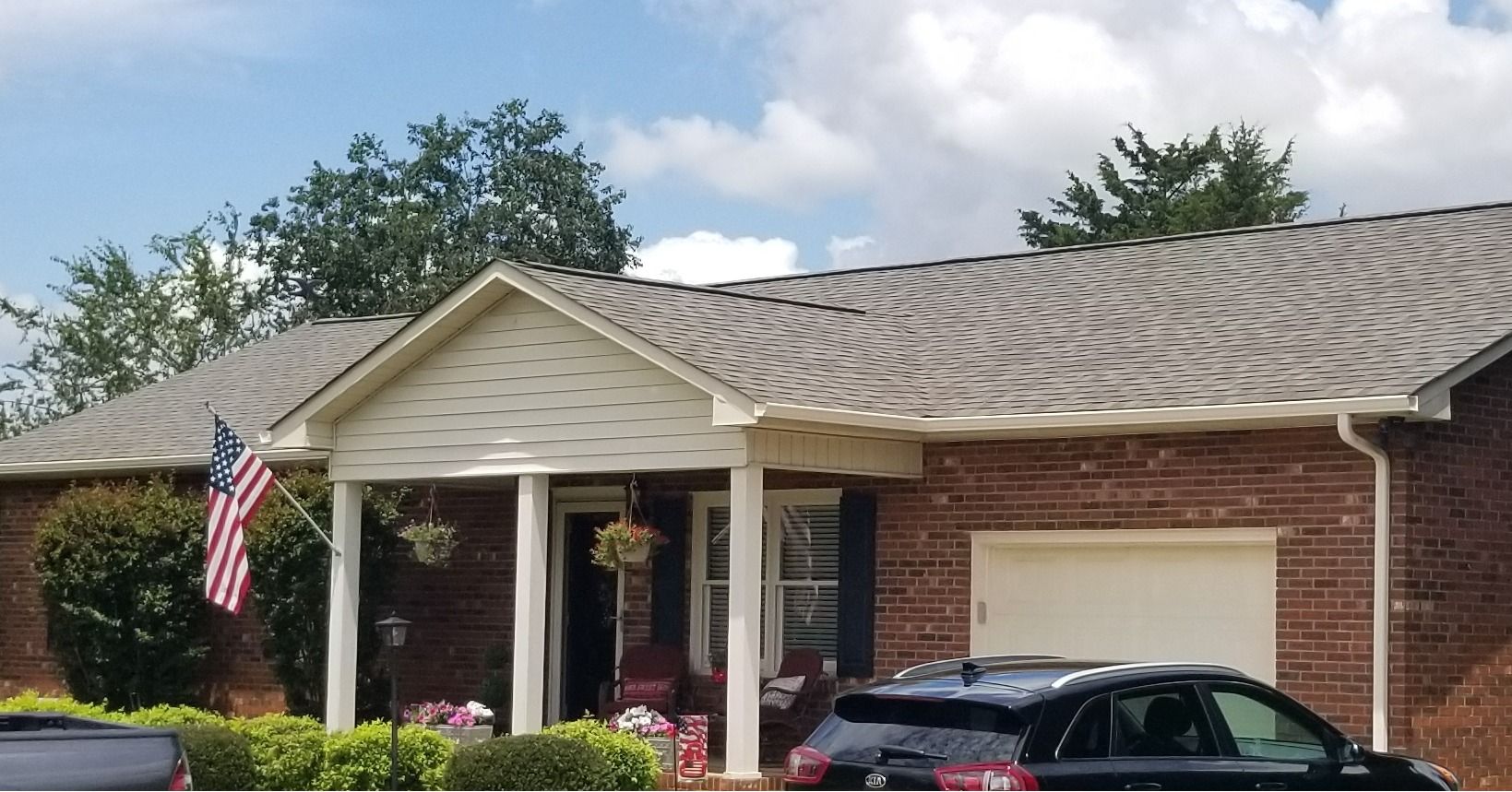 A brick house with a car parked in front of it.