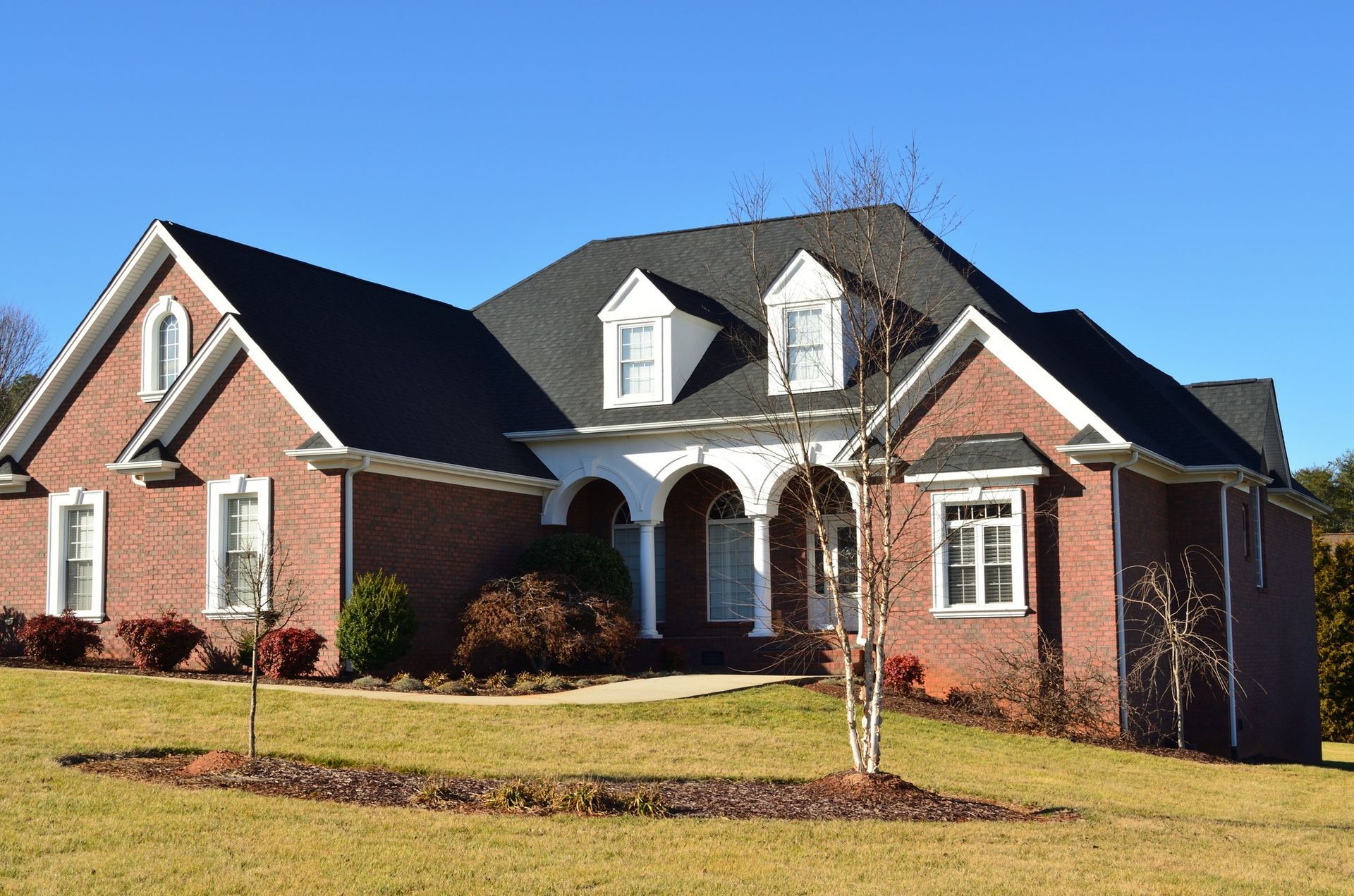 A large brick house with a black roof