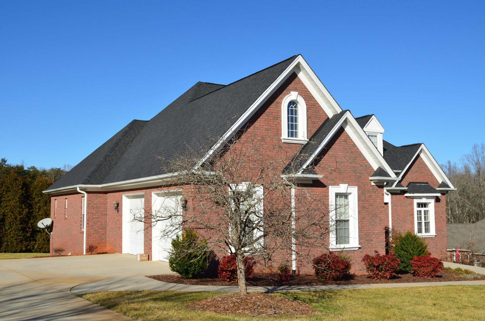 A large red brick house with a black roof