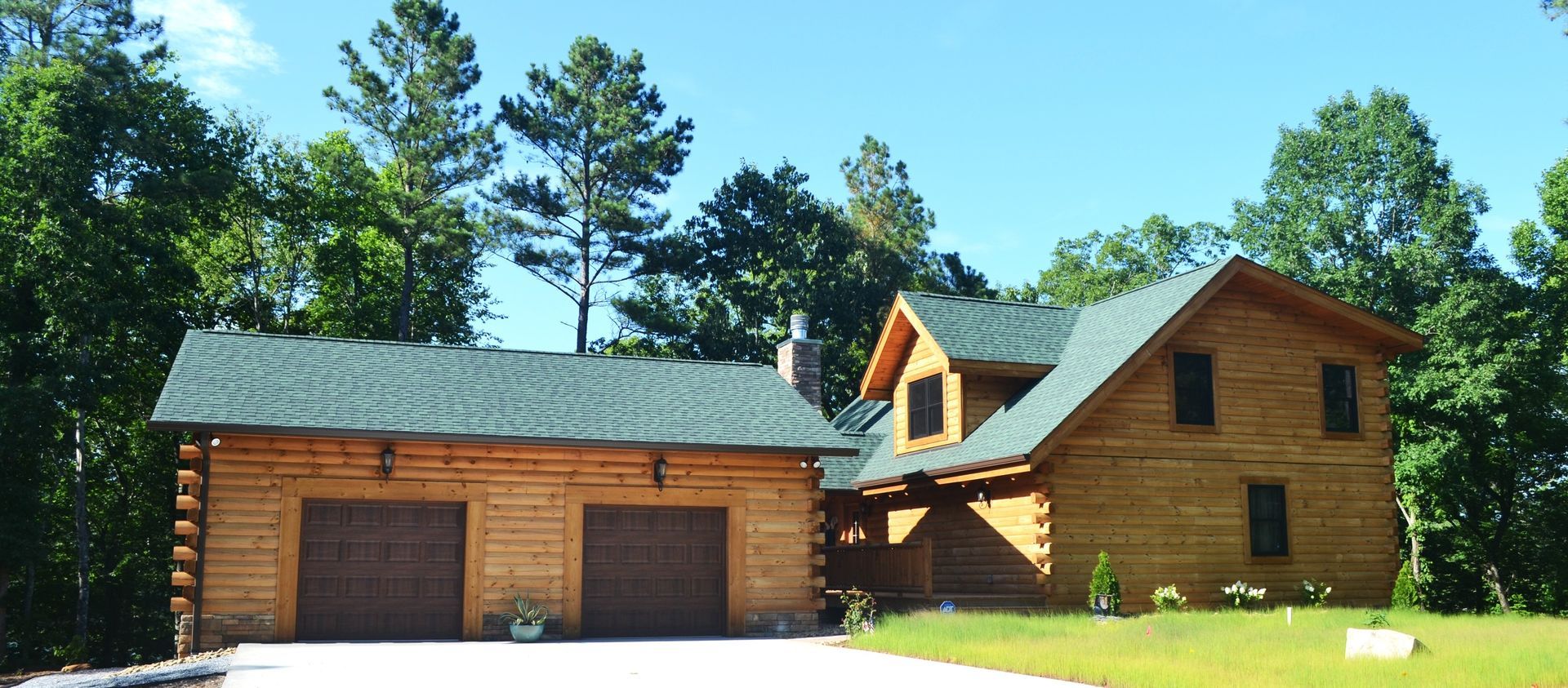 A large log cabin with a green roof