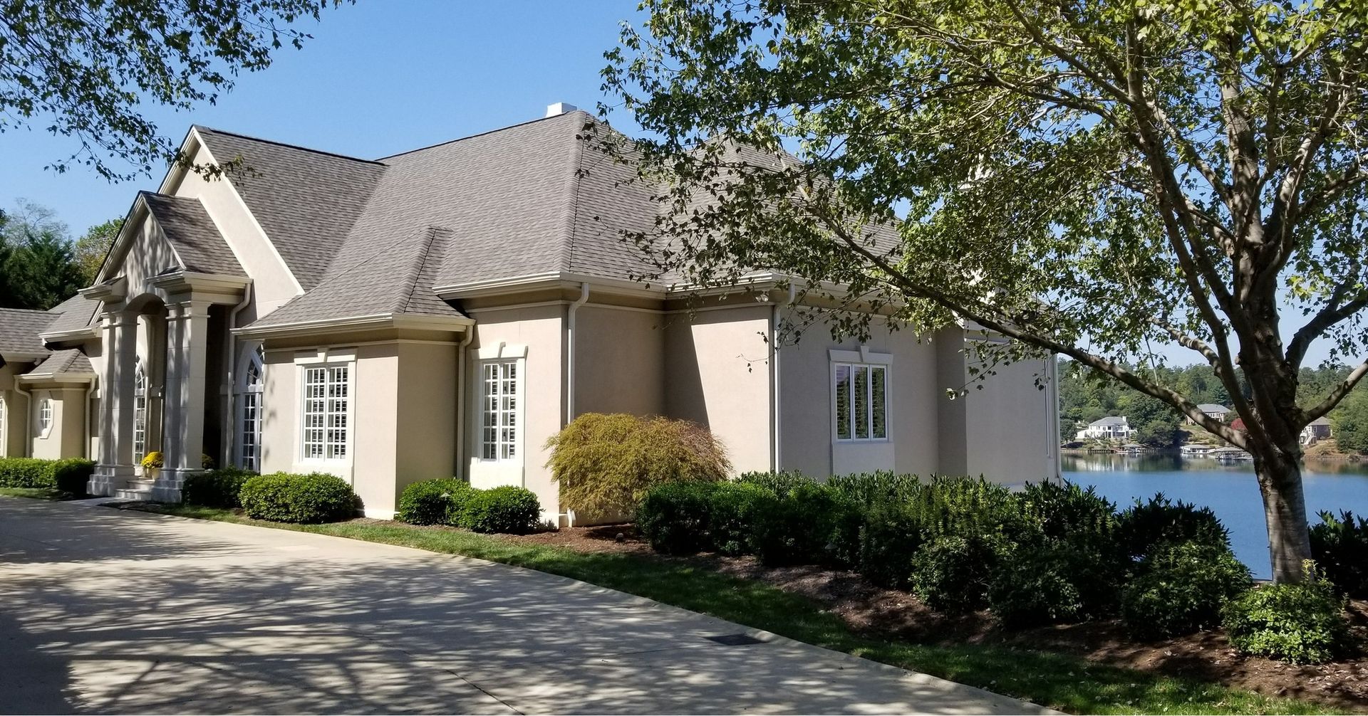 A large house sits next to a body of water