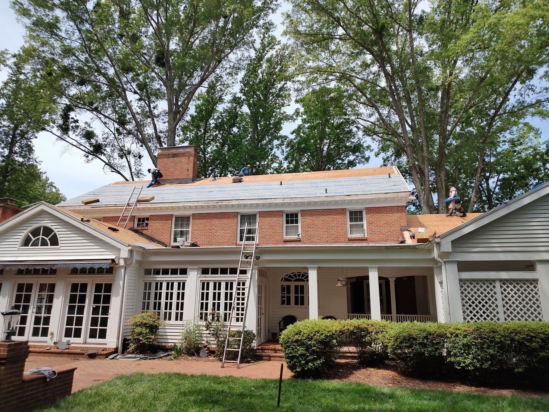 A large house with a roof that is being installed