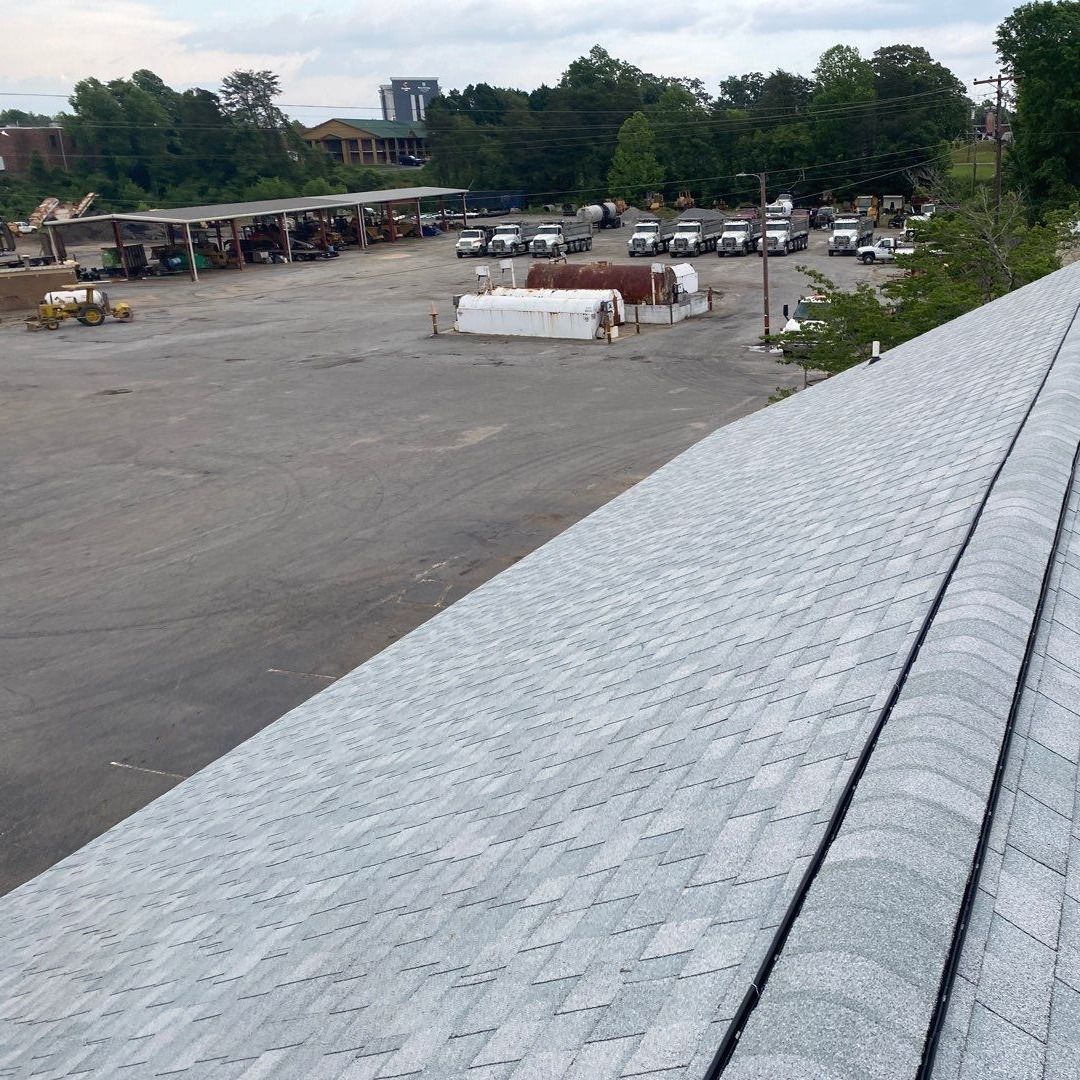A rooftop view of a parking lot with a lot of cars parked in it.