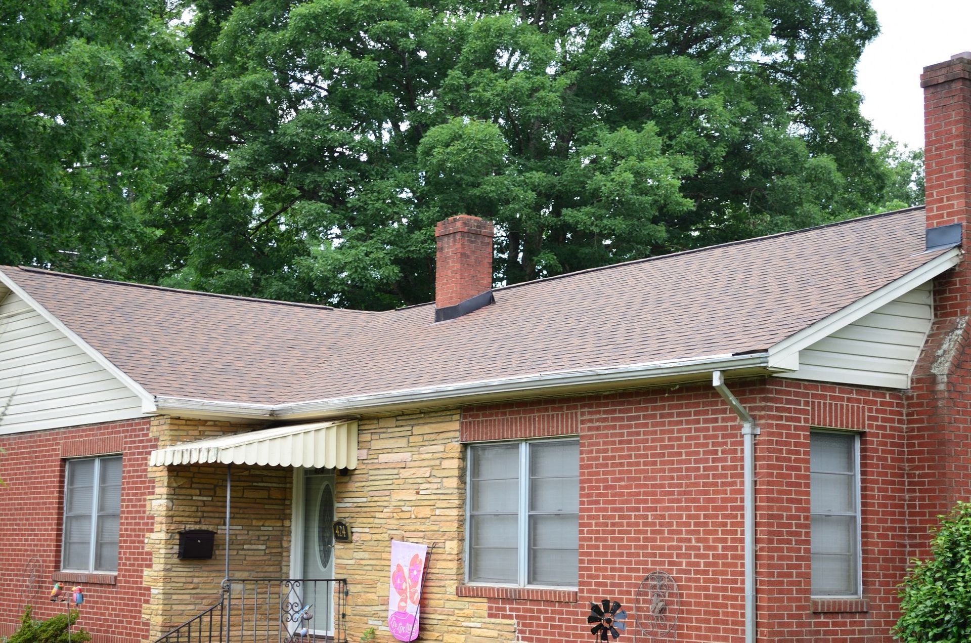 A brick house with a brown roof and a chimney