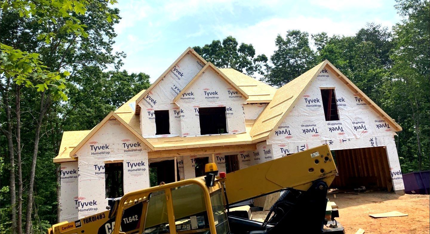 A large house is being built with a crane in front of it.