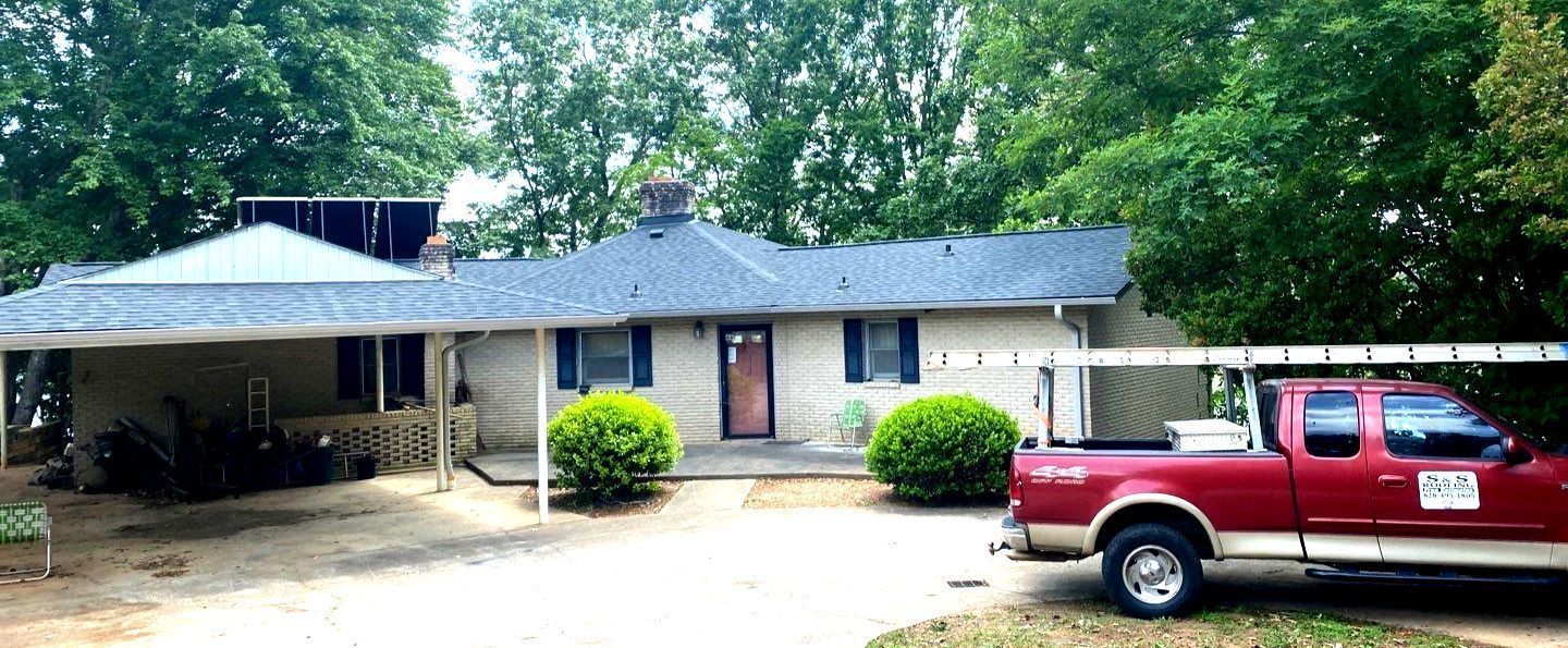 A red truck is parked in front of a house