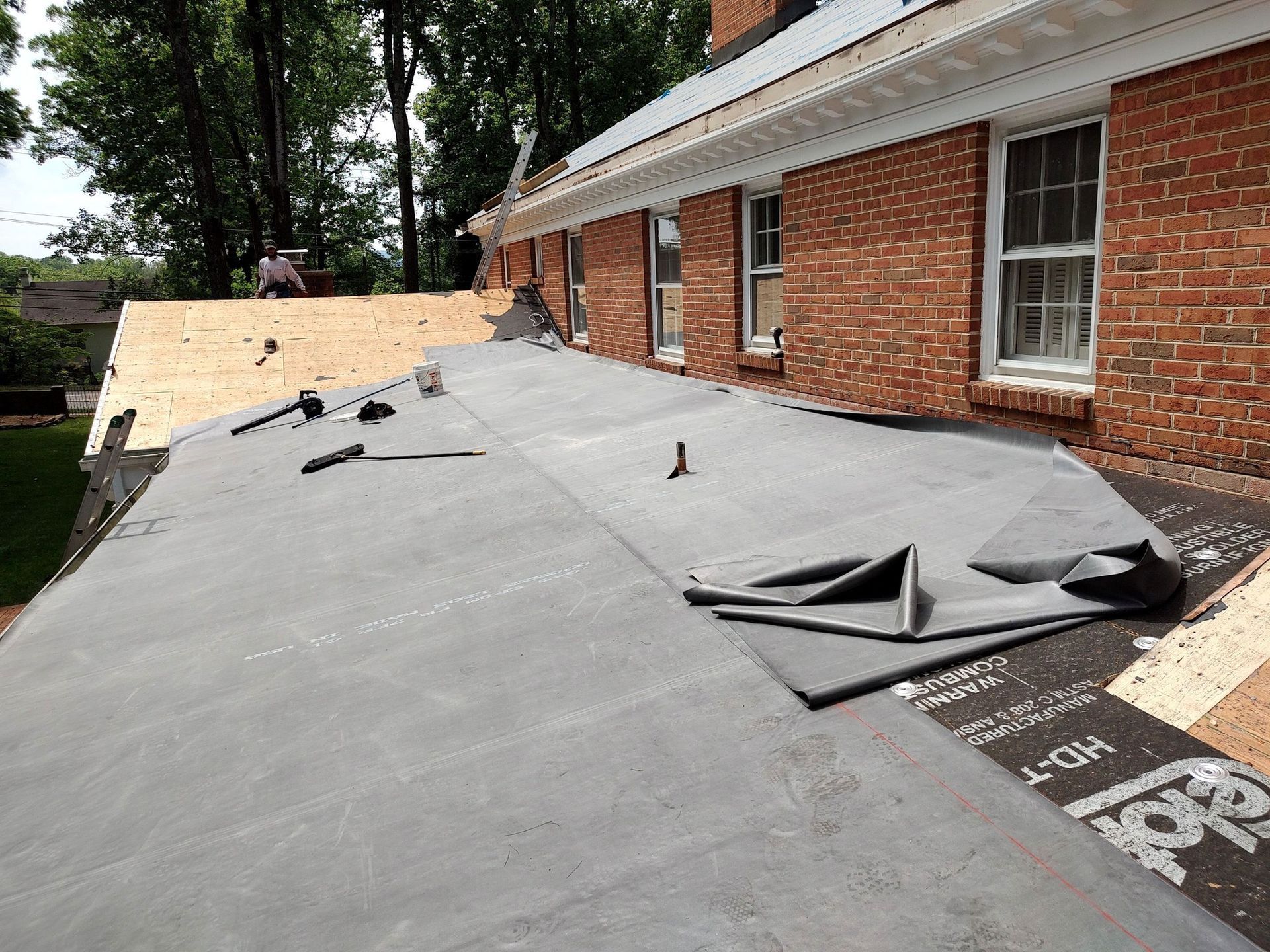 A roof is being installed on a brick house.