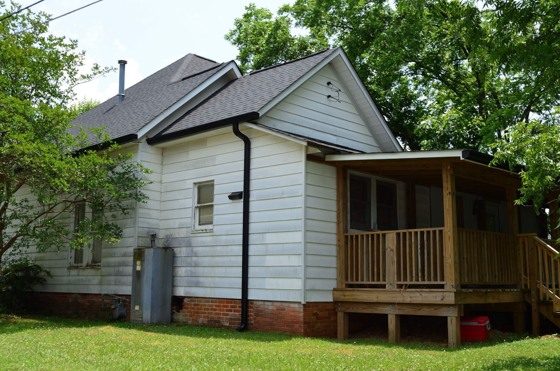 A small white house with a screened in porch