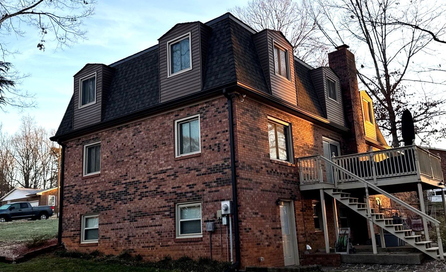 A large brick house with stairs leading up to the second floor.