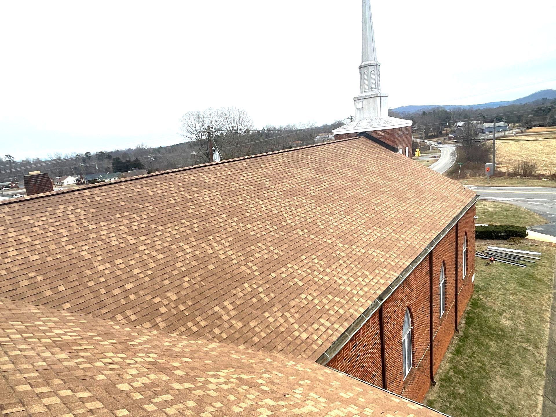 An aerial view of a church with a steeple on top of it.