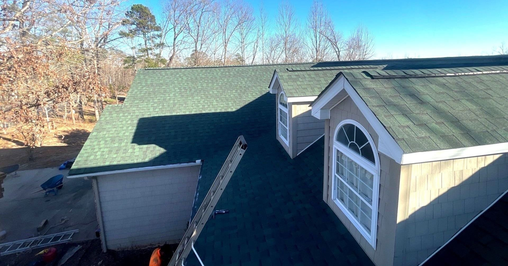 An aerial view of a house with a green roof and two windows.
