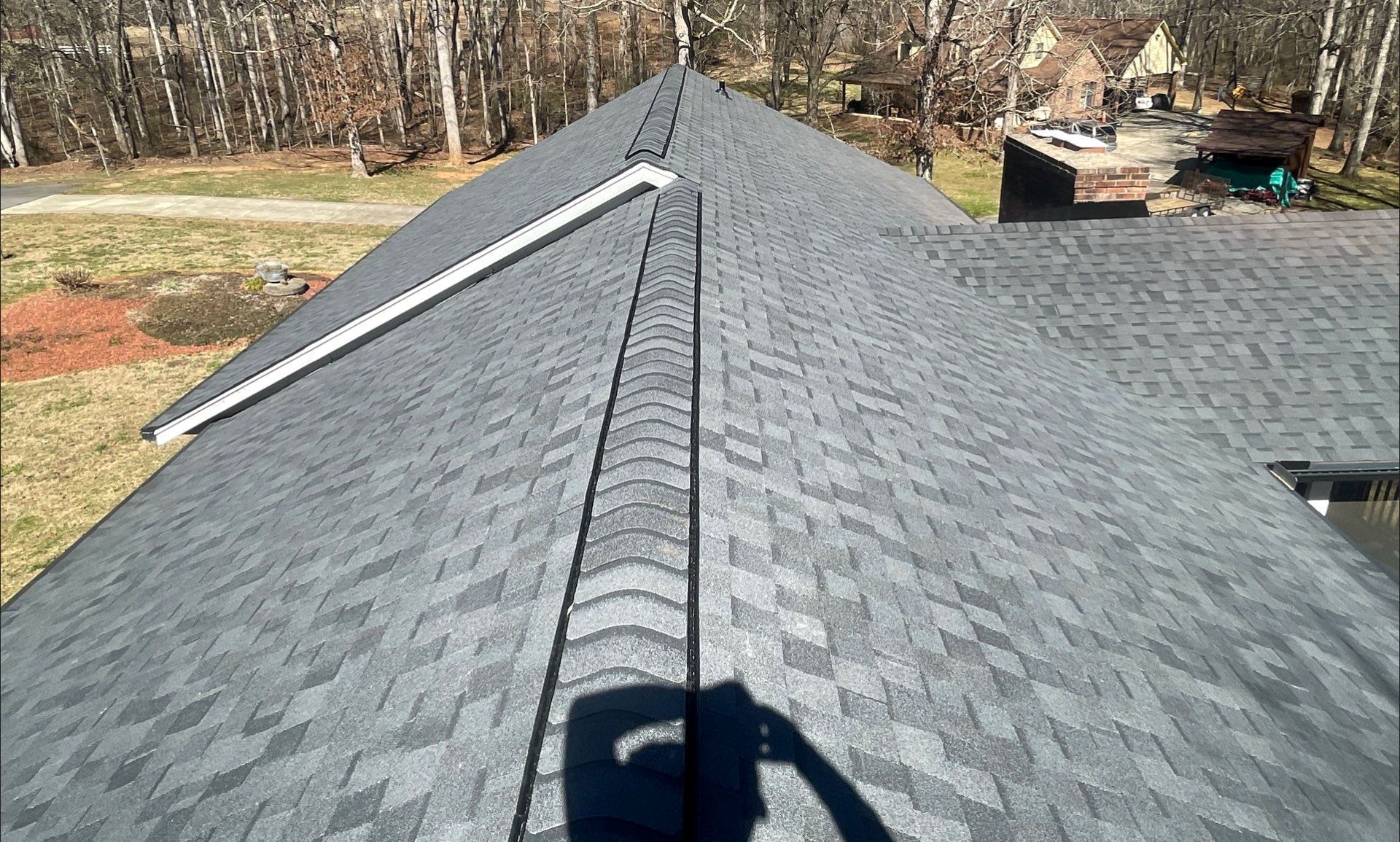 A close up of a roof with a shadow of a person on it.