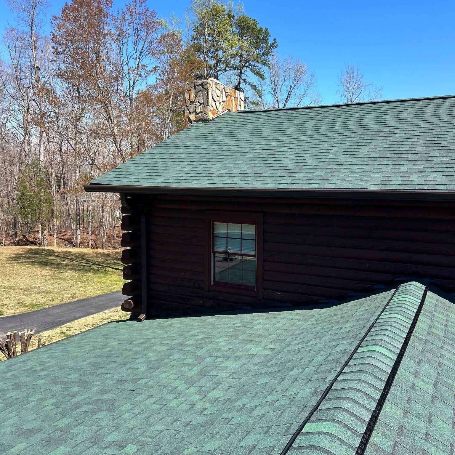 A log cabin with a green roof and a window