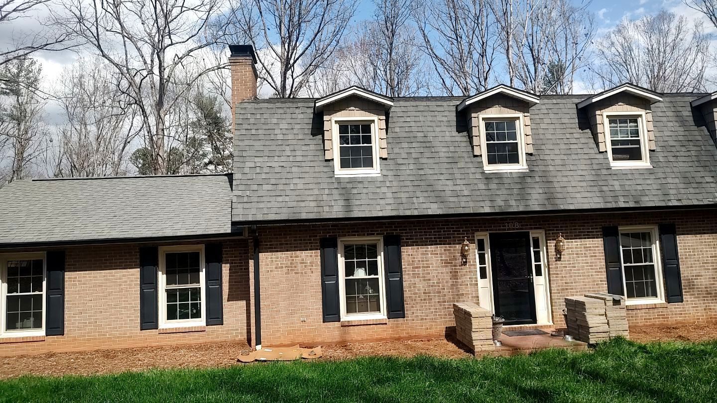 A large brick house with a slate roof and black shutters
