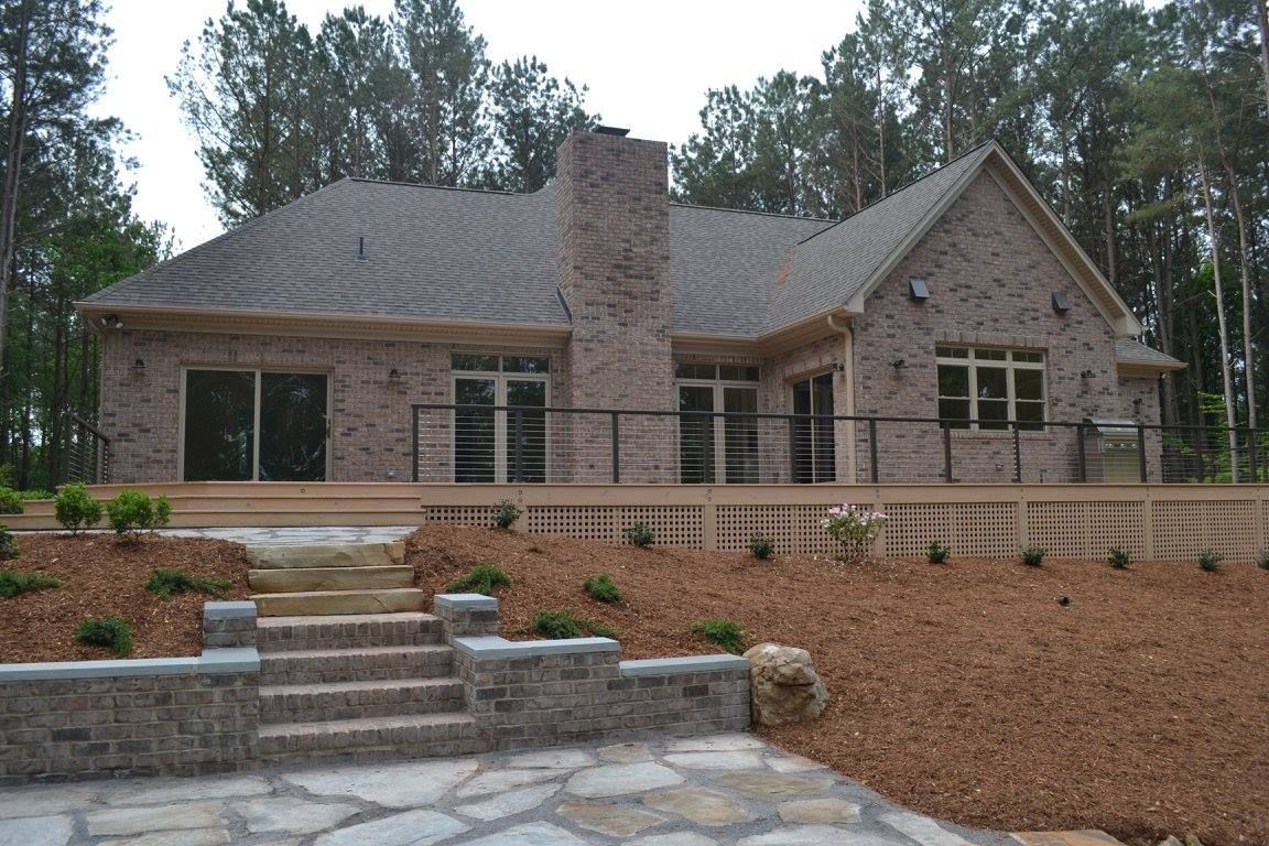 A large brick house with a deck and stairs