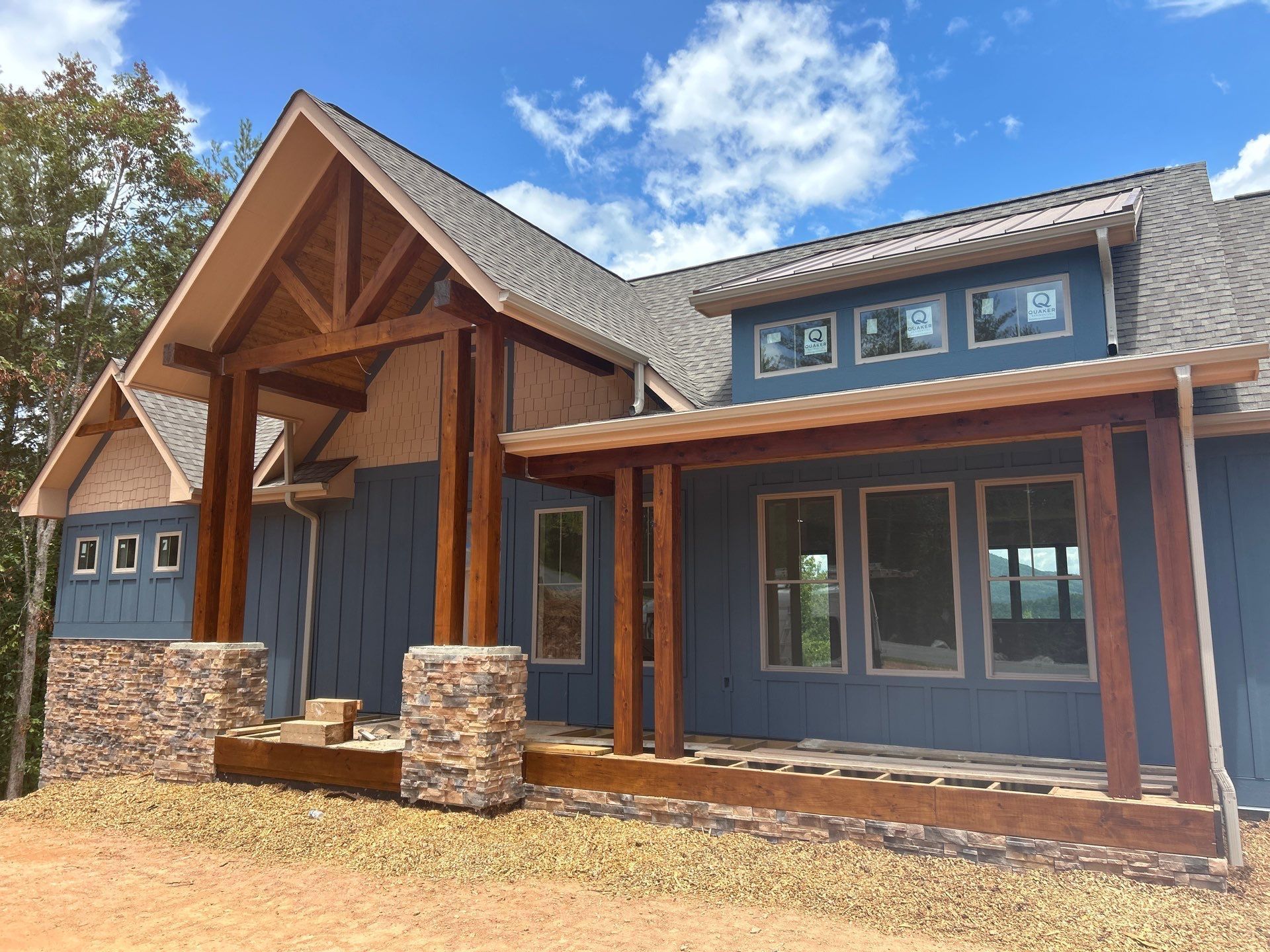 A large blue house with a porch and a lot of windows.