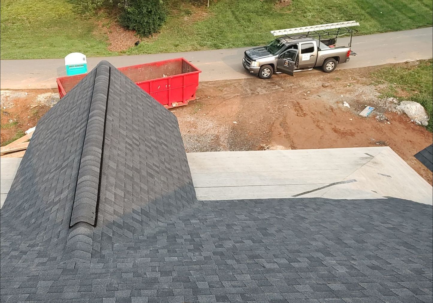 A truck is parked on the side of the road next to a roof.