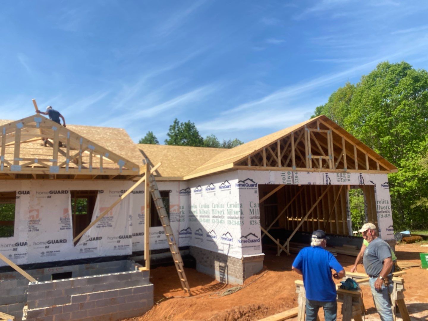 A group of men are standing in front of a house under construction.
