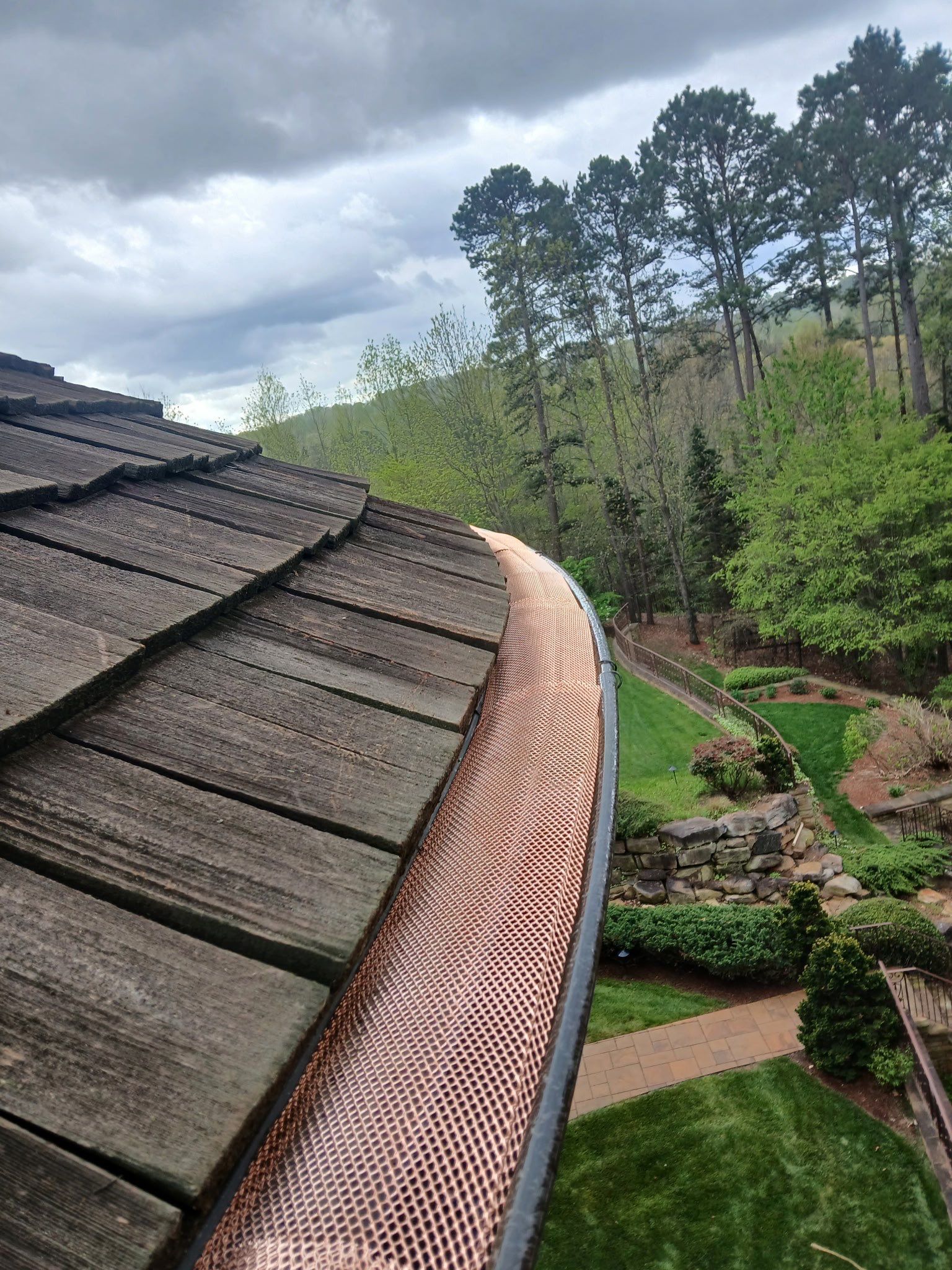 A wooden roof with a copper gutter on it.